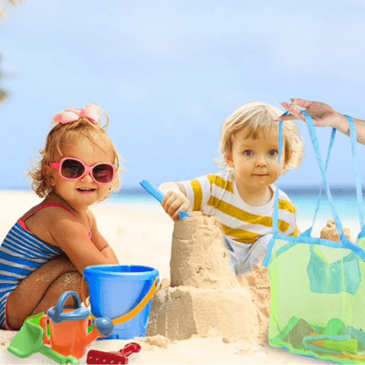 Deux enfants à la plage font un chateau de sable et leur maman range les jouets dans le Sac de Rangement  jouets - CarryTidy