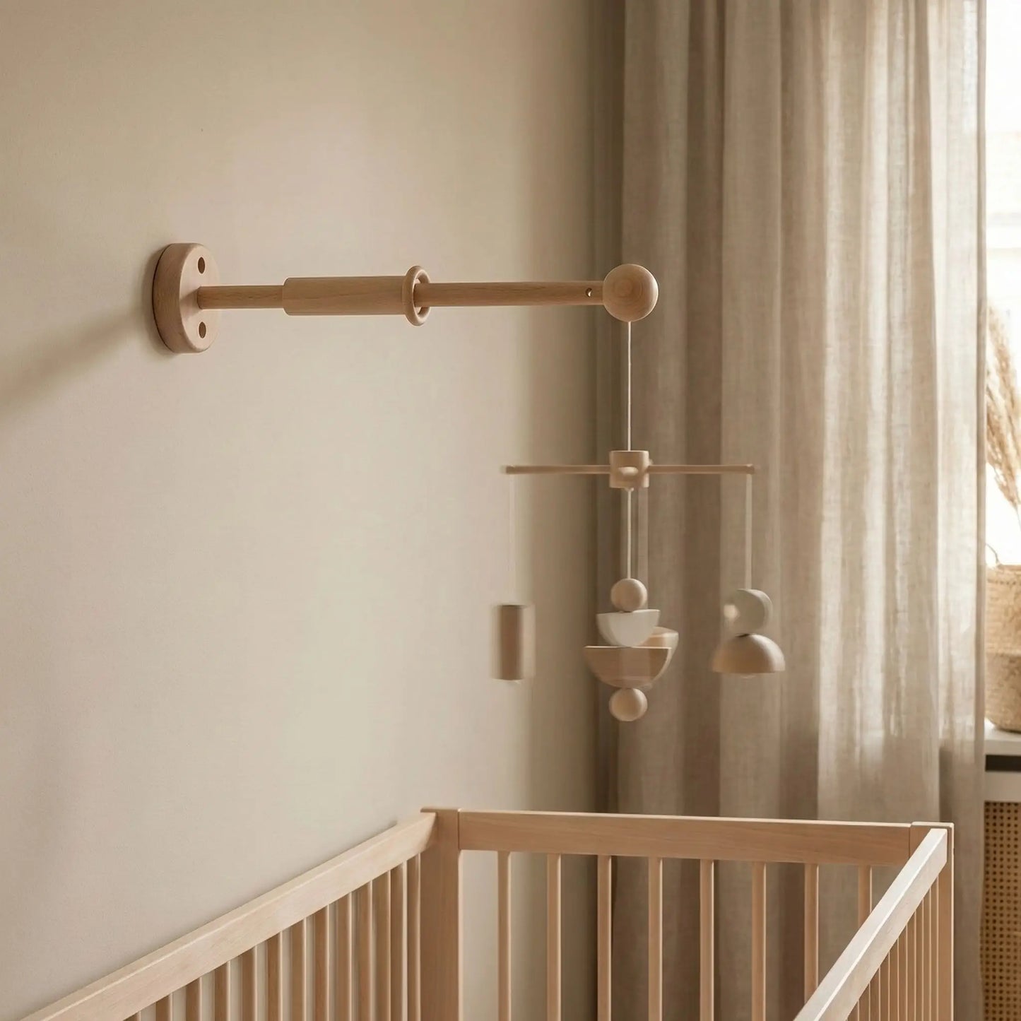 support mobile bébé en bois PtiFix à fixation murale installé au-dessus du berceau de bébé